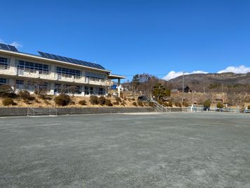 北に八ヶ岳、東に飯盛山、西に南アルプスを見ることができます。 - 八ヶ岳コモンズ グランド（校庭）の室内の写真