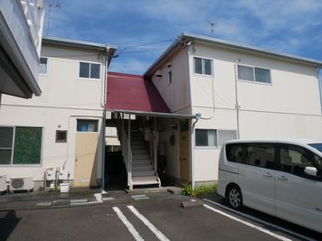 赤い屋根の階段を上がり、左側に玄関ドアがあります。 - ナカジマハイツ 総和建工西焼津貸スペース、貸会議室、自習室の入口の写真