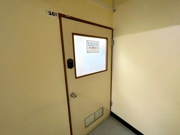 【廊下を突き当りまで進んで左側に201号室があります。ドアノブの上に付いている黒い電子錠を予約完了時にお伝えしている番号で開けてください】 - TIME SHARING 秋葉原 和泉ビル 201の入口の写真
