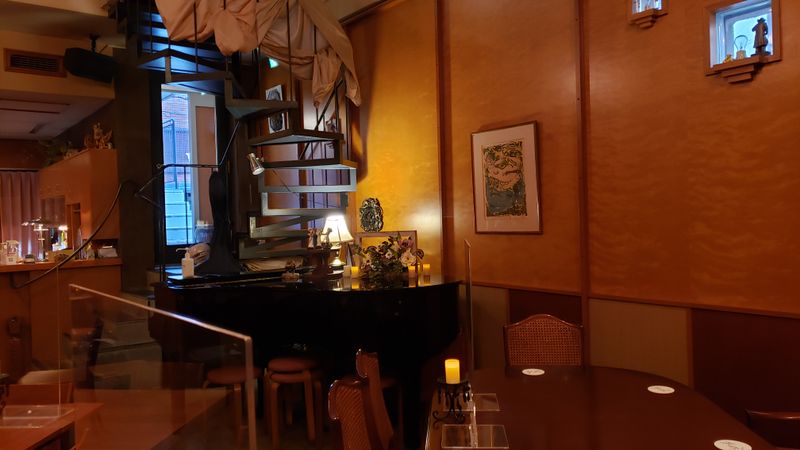 グランドピアノとテーブル - 隠れ家風ライブホール1階個人練習・個人レッスン用レンタル ライブ営業時間外レンタルスペース1階（個人練習・個人レッスン用）の室内の写真