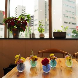 季節の花々がテーブルを彩ります。 - メトロシティ小伝馬町２０２　Ｃｒａｆｔ　ｄｉｐ　３ｎｏｗａ 日本橋小伝馬町　Craftdip 3nowa　レストランカフェ　の室内の写真