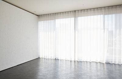 自然光の入る大きな窓と白塗り壁 - studio PLOTの室内の写真