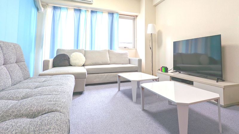 3人掛けソファー2つと大型テレビ - SKY 渋谷の室内の写真