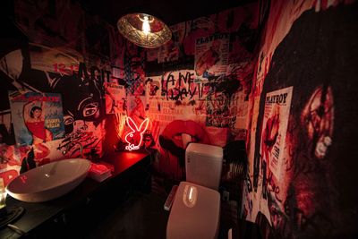 全面デザインクロスのトイレは、あえて暗いライトと赤のネオンライトを使用しアンダーグラウンドなイメージにぴったりです。 - Photo Studio NY 水中撮影可能な動画撮影スタジオの室内の写真