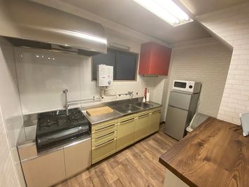 2層シンク、給湯器、ガス台、冷蔵庫、オーブンレンジが完備された、数人で作業できる広いキッチンです。 - 飯田橋パーティスペースの室内の写真