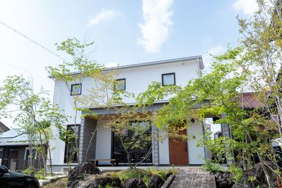 白い壁の外観と庭が目印です。 - Together+豊山 キッチン付きレンタルスペースの外観の写真