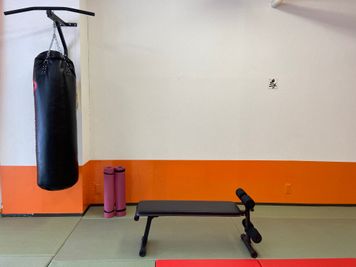 ダンベル 、トレーニングベンチ、サンドバッグ、ミット、ボクシンググローブなどのトレーニンググッズもすべて揃っています - 「フィットネスジム＆道場」トレーニングスペースの室内の写真