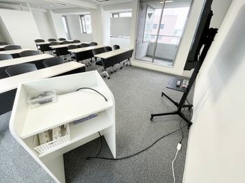 【モニターへは、司会台に伸びているHDMIケーブルとお手持ちのPCを接続するだけで簡単に投影が出来ます】 - 【閉店】TIME SHARING 代々木 新宿明治通りビル 【閉店】10Fの室内の写真