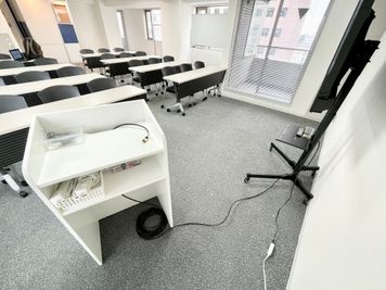 【モニターへは、司会台に伸びているHDMIケーブルとお手持ちのPCを接続するだけで簡単に投影が出来ます】 - 【閉店】TIME SHARING 代々木 新宿明治通りビル 【閉店】9Fの室内の写真
