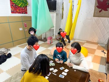 大人はボードゲームを楽しみ、子供はエアフローヨガの布で遊べます。 - 柏市旭町レンタルルーム【全面赤ちゃんマット、大型鏡アリ】 多目的スペースの室内の写真