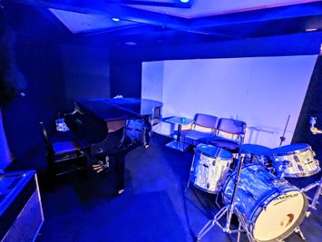 舞台上にはグランドピアノ(別料金)、ドラムセット(別料金)などを常設。PA使った音楽ライブ、プロジェクターによる上映会などにも利用できます。 - 三鷹RIスタジオ 三鷹RIスタジオ(アールアイスタジオ)の室内の写真