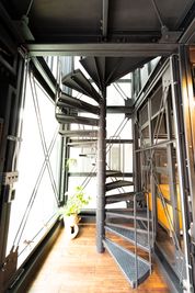 まるで“恐竜の肋骨”をイメージさせる鋼鉄製螺旋階段『ダイナソーボーン』 - DAYTONA HOUSE大阪中央の室内の写真