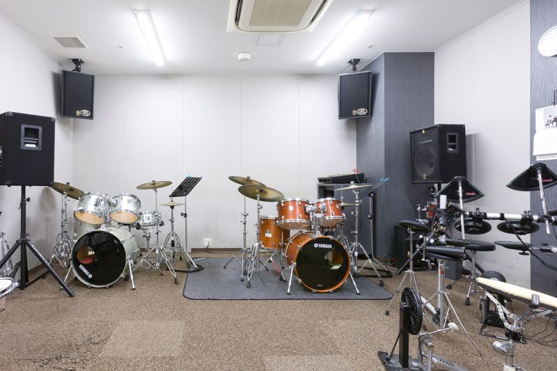 部屋内観　ドラムセット2台(ヤマハ製)、電子ドラム1台(ヤマハ製)、CDプレイヤー、ミキサー(ヤマハEMX5016CF,オーディオケーブル)、譜面台あり - ミュージックアベニュー池袋 ドラム防音部屋 17番教室の室内の写真