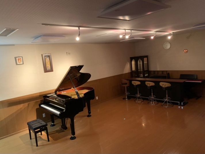 バーカウンターとグランドピアノ。
その他ソファ3台、椅子10脚等。 - スタジオルナブランカの室内の写真