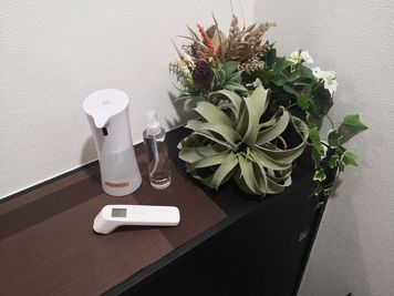スペース入り口です。コロナ対策備品がございます（体温計、アルコールスプレー、次亜塩素酸水）。ほかに除菌シートもございます。 - あくびのすき間　東梅田店 🚩大型サイズの低反発施術ベッドがあるサロンですの設備の写真