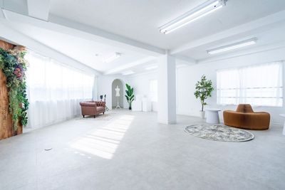 使い方次第で様々な演出が可能 - 都内の白ホリ自然光 撮影スタジオ 壁一面の大きい窓から柔らかい自然光が降り注ぐ真っ白なスタジオの室内の写真