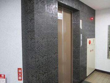 奥のエレベータで6階までお越しください。 - 三豊ビル 30名までの会議スペース401の入口の写真