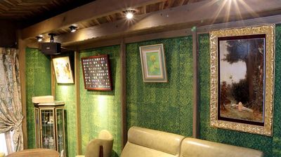 もう一方の部屋の壁は、リラックスできる緑の壁。オーナーこだわりの絵画が、楽しい雰囲気を演出します。 - ワインバー・クリマ ワインサーバーがあるレンタルスペースの設備の写真