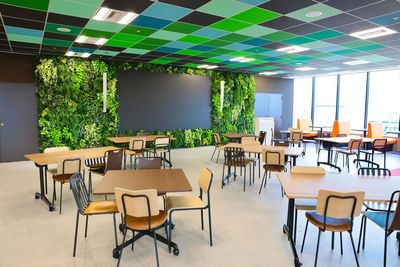 天井や壁面にグリーンカラーを配置し、自然をイメージしたエリア。ご来客者様との打ち合わせにも使えるオープンな空間です。 - 株式会社ハッピースマイル