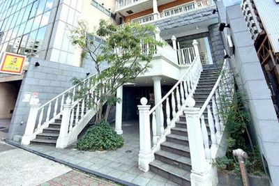 白色の階段にオレンジのマンションが目印 - レンタルサロンBonheur レンタルサロンの外観の写真