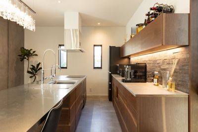 広々使えるアイランドキッチン。ステンレスの天板に木の組み合わせはオリジナルオーダーメイド
 - まるでホテルのような空間 キッチン付きリビングダイニングの室内の写真