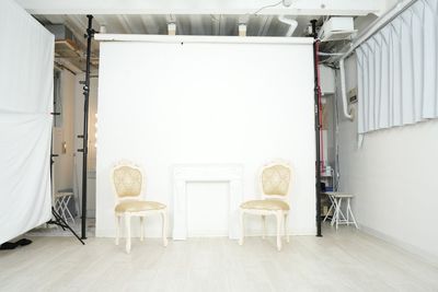 漆喰のパーテーションの前に猫足椅子とキューピットが彫られている白のアンティークなマントルピースをセットして撮影が可能 - 撮影スタジオ「スタジオぶぶ」の設備の写真