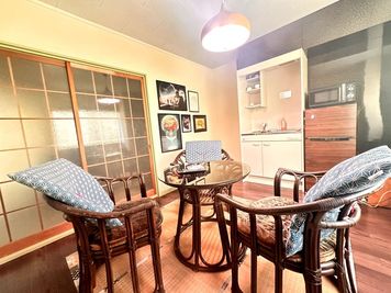 梅の３人掛けダイニングテーブルと簡易キッチン。 - ルミエールドボナール　多目的スペース「松」「梅」「竹」「桜」 多目的スペース2DK貸切Wi-Fi冷蔵庫電子レンジ簡易キッチンの室内の写真