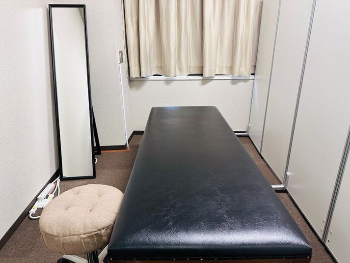 半個室　施術用ベッドのあるパーテーションで区切られた半個室スペース
・全身鏡
・丸椅子
・椅子
・延長コード
・ハンガー - S ＊PLACE 名古屋駅前 リラクゼーションスペースの室内の写真