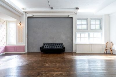 3人がけの黒いソファは、コンクリート壁との相性抜群
 - 神楽坂スタジオ レンタル撮影スタジオの室内の写真