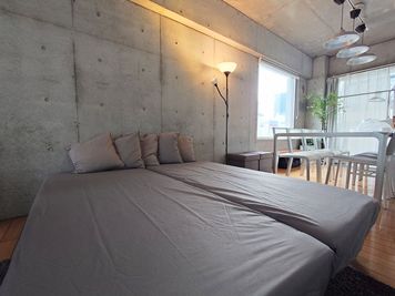 普段はL字に配置していますが、ゴロゴロできるマットレスもご用意しています。 - エクセルシオールスペース南池袋店 ✨ゴミ捨て無料✨コンクリート打ちっ放し|女子会・パーティー🍷の室内の写真