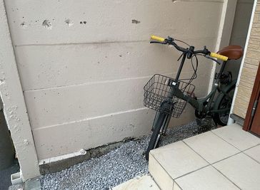 玄関前に自転車を置けます。
事前に連絡いただければ場所を確保いたします。当日も１階受付にて営業中の際は対応致します - エイトボディの入口の写真