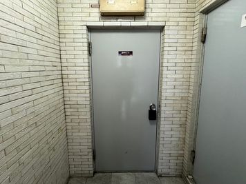 扉を入って正面突き当たりにある「ブリックス神田」の入口のドアノブに、黒いキーボックスがかかっています。 - ブリックス神田 【ブリックス神田】グリーン溢れるブルックリンスタイルのスペースの入口の写真