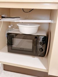 キッチン下にレンジ、洗面器、ボール、トレーがあります。（ミネラルウォーターは店舗用のためご利用不可です） - 白い部屋  完全個室 | 白金台駅1分  目黒駅12分 期間限定10％OFF |  wifi無料｜備品充実の完全個室の設備の写真
