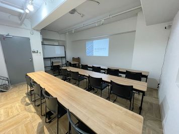 プロジェクター投影（電気は半分消した状態）
プロジェクターはワゴンに乗せてお好きな場所に移動することも可能。 - 【新大阪】セミナーや研修に◎貸会議室・レンタルスペースCota 【徒歩4分】会議や研修に使えるおしゃれなオフィスビルの多目的空間の室内の写真