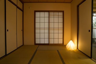 洋室との間は無双窓付きのアンティークな黒色引き違い戸に変えています。倉又史郎のオバQ照明器具が置いてあります - チサンマンション102室 貸室の室内の写真