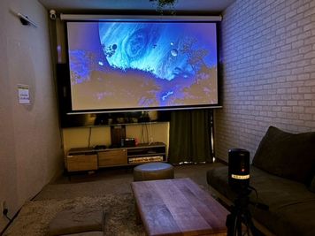 さらに、奥の壁全面に広がる100インチ高画質プロジェクターも完備。セミナー、鑑賞会も！ - シエスタ烏丸 〈シエスタ烏丸〉【11名～20名様専用】の室内の写真