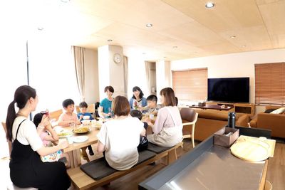 7人掛けの無垢材のダイニングテーブル6人掛けの本革ソファ-　65インチ有機ELTV - レンタルスペース　『時の間』 駅徒歩2分！屋内スペースと屋外スペースのあるレンタルスペースの室内の写真