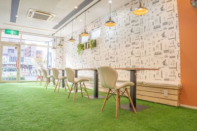 セルフカフェ桜山店の店内：ベンチシートに椅子、机が置かれたカフェ店内 - セルフカフェ桜山店 桜山駅5分！快適ブースで集中力UP！勉強・リモートワークの入口の写真