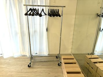 移動式ハンガーラックには木製のハンガーが10本ほど常備 - more新宿2号店 	撮影スタジオの室内の写真