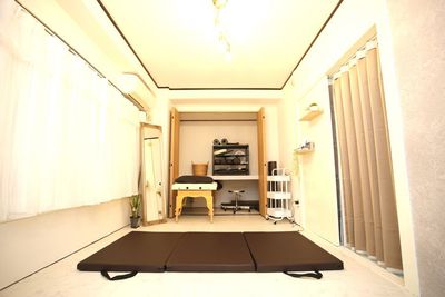 施術ベッドを折りたたまず、クローゼットに半分収納した状態でタイ古式マットをご使用いただけます。（奥のお部屋） - レンタルサロンRainbow 赤羽店（Large） salonの室内の写真
