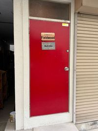 赤い扉の向こうには２階への階段があります。 - レンタルスペースFieldwood レンタルスペースFieldwood多目的ルームの入口の写真