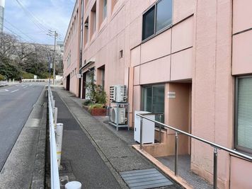 手前の入り口が会議室エリア。入って左手のスイッチで電気をおつけください。

奥がコーワークエリアです。 - クリエイティブガレージ星が丘 6名会議室の入口の写真