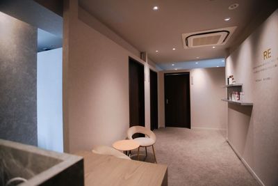 レセプション：カウンター、ウェイティングチェアー＆テーブル

ウェイティングチェアー＆テーブルはオプションでお部屋での使用可能です。 - 脱毛・セルフホワイトニングサロン　RE レンタルサロン　自動ベッド付き個室ルーム【deux】の入口の写真