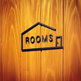 ドアに付いているこのロゴを目印にお越しください。 - レンタルスペースROOMSの入口の写真