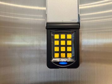 【入口の左側にあるシルバーのカバーを持ち上げ、パネルに暗証番号を入力すると開錠されます。】 - TIME SHARING シテヌーブ北千住30A棟 会議室の入口の写真