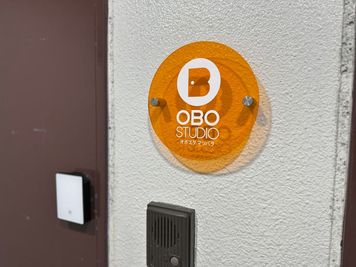 入口横にもアクリル看板が設置されています。こちらの扉からお入りください。 - OBOスタ松原の入口の写真