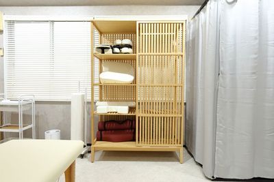 マッサージ備品・ヨガマット収納棚 - サロンcode博多 サロンcode博多 個室ヨガ 大きなアーチミラーの前で癒し空間の設備の写真