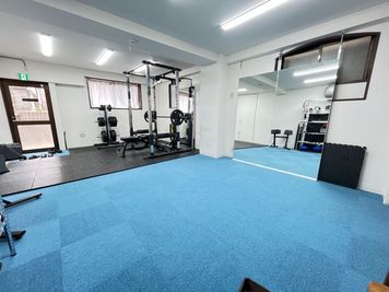 パワーラックの横のスペースはダンベルトレーニングやストレッチでお使いください。 - MIYAZAKI GYM沼袋店の室内の写真