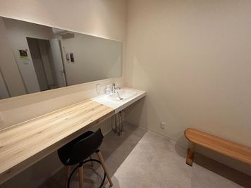 木製ベンチと広々とした洗面台がある、清潔感あふれる更衣室。トレーニング前後も快適にお過ごしいただけます。
 - 倉敷・和モダン レンタルスペース 【一棟貸 ver.】倉敷・和モダン レンタルスペースの室内の写真