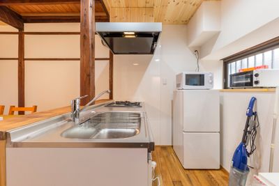 一階：キッチン。冷蔵庫・電子レンジ・トースター・調理器具（鍋等）あります。 - 月島長屋 多目的スペースの室内の写真